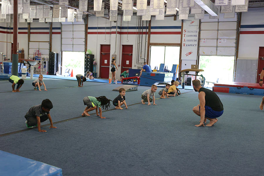 male gymnast in blue shirt on bar